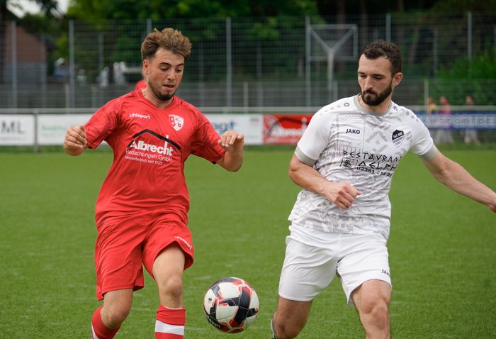 Two footballers challenging for the ball