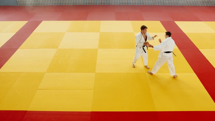 Judoka mid-throw on the tatami