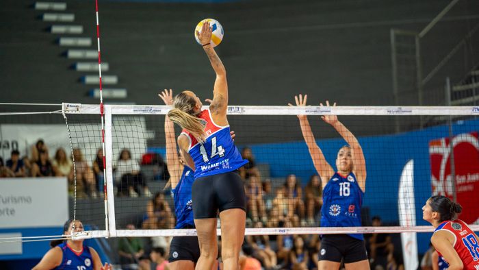 Volleyball player spiking at the net